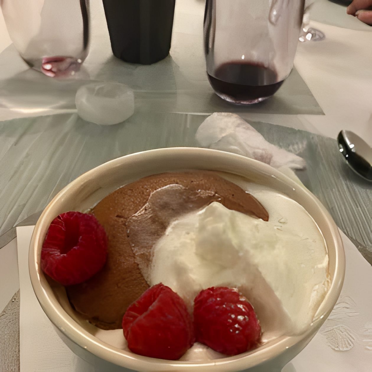 Dessert topped with raspberries and whipped cream