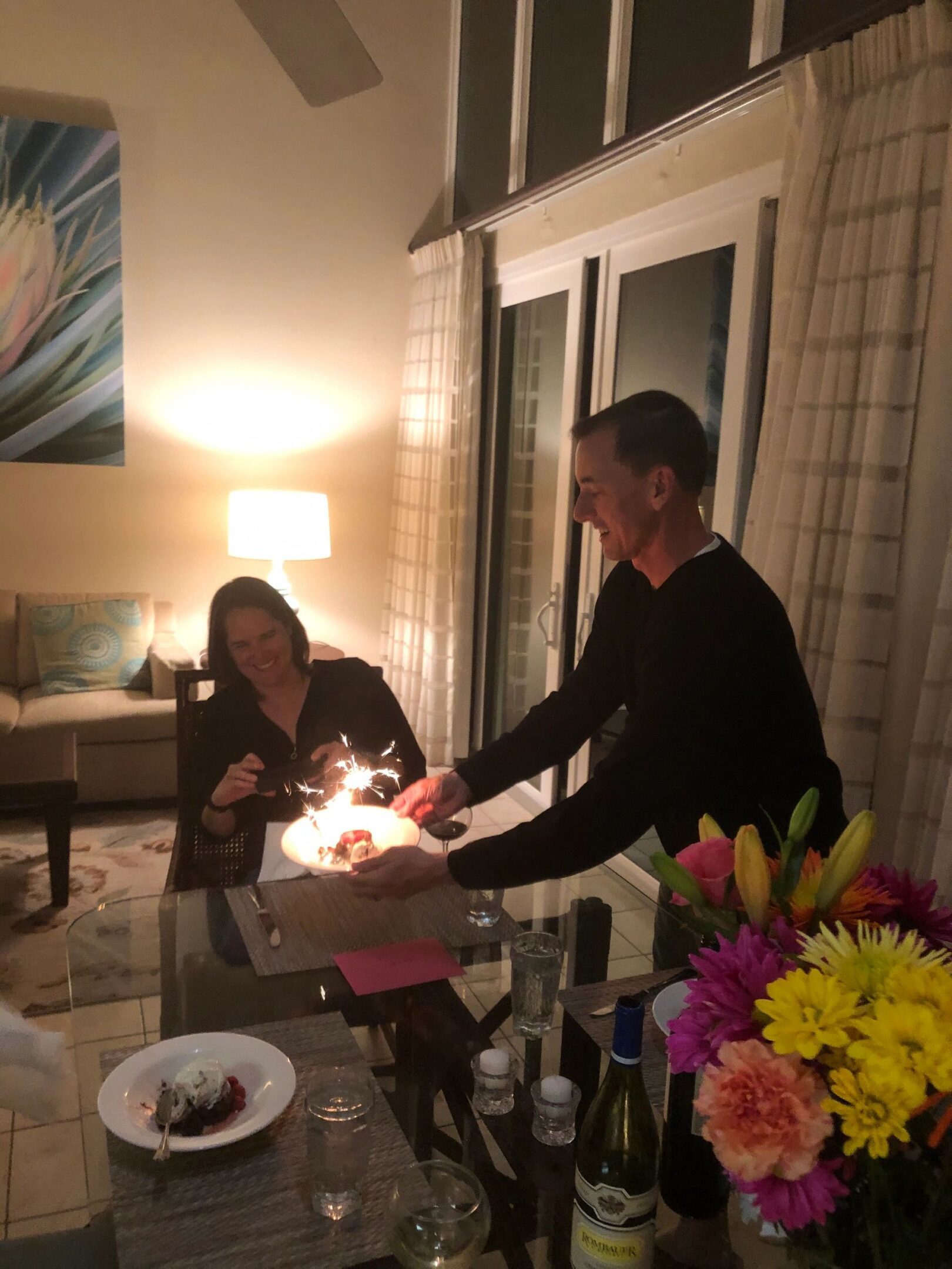 Couple celebrating with cake and flowers