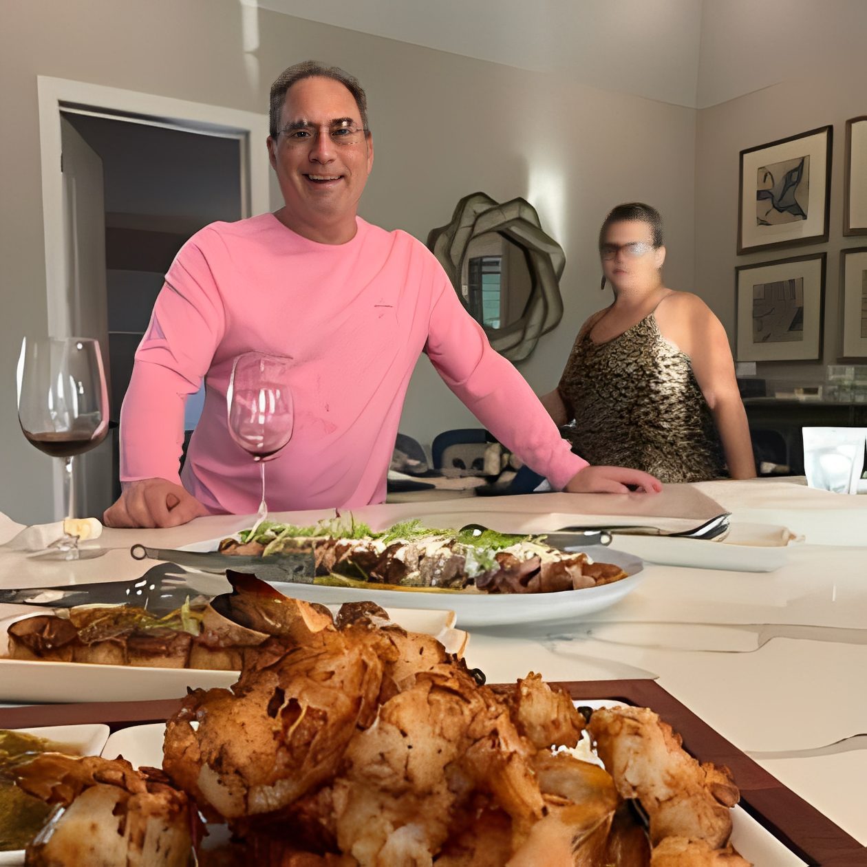 Man in pink shirt at dining table