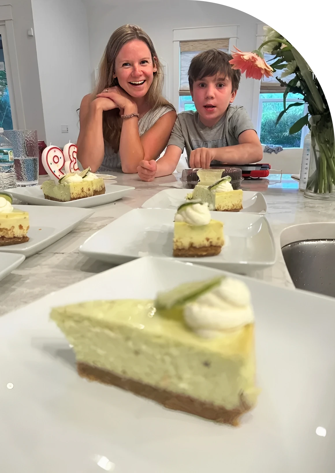 Smiling woman and boy behind cheesecake