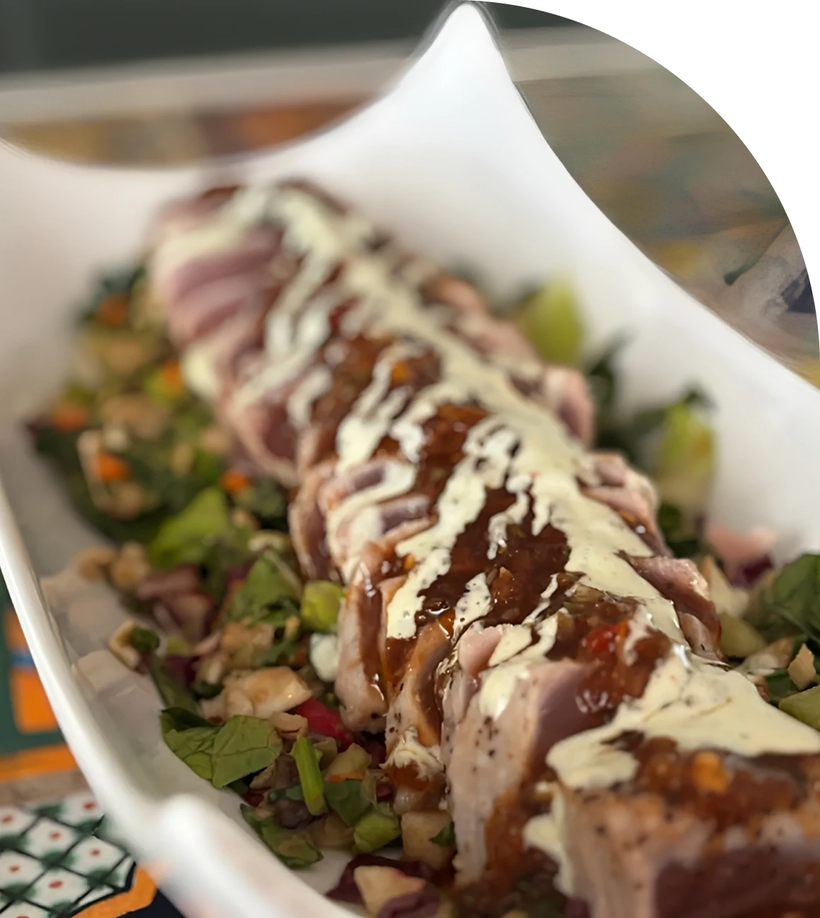 Sliced tuna with sauce on a salad